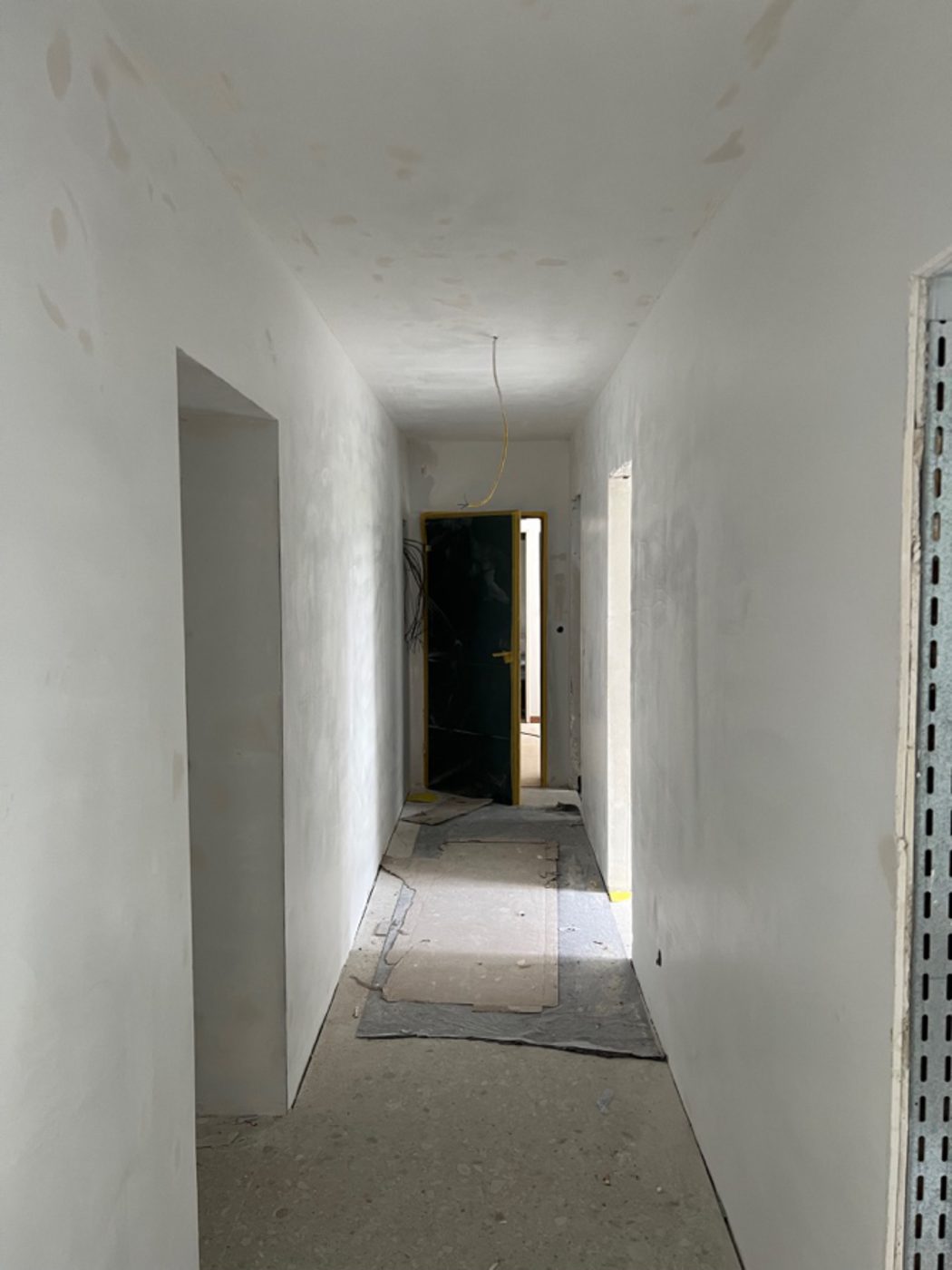 Flur im Rohzustand mit verspachtelten Wänden vor dem Endausbau