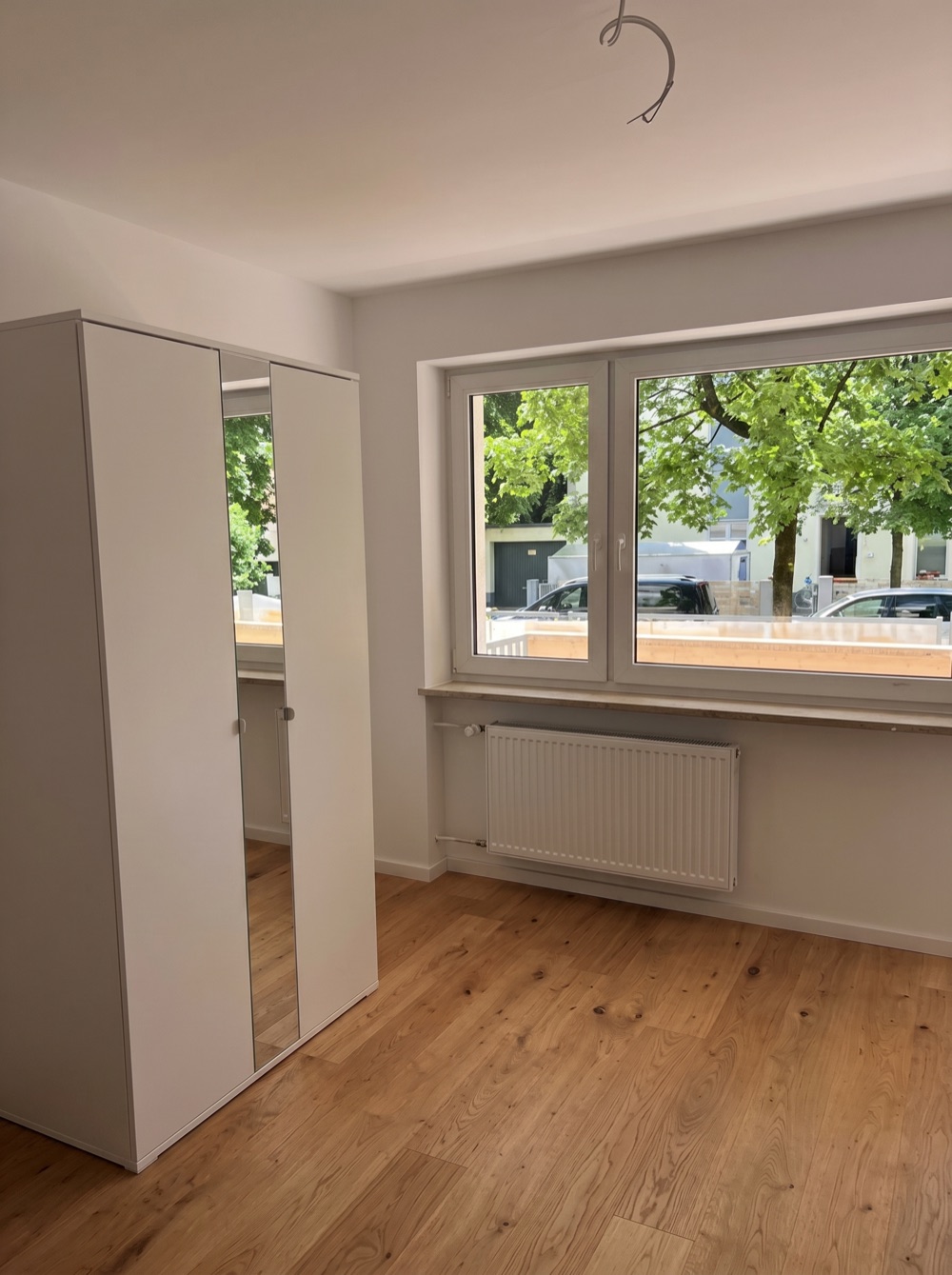 Heller fertiger Wohnraum mit Echtholzboden und Einbauschrank